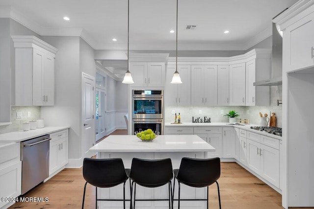 451 Woodbury Dr, Jackson, NJ 08527 - kitchen featuring stainless steel appliances, crown molding, wall chimney range hood, white cabinets, and light countertops