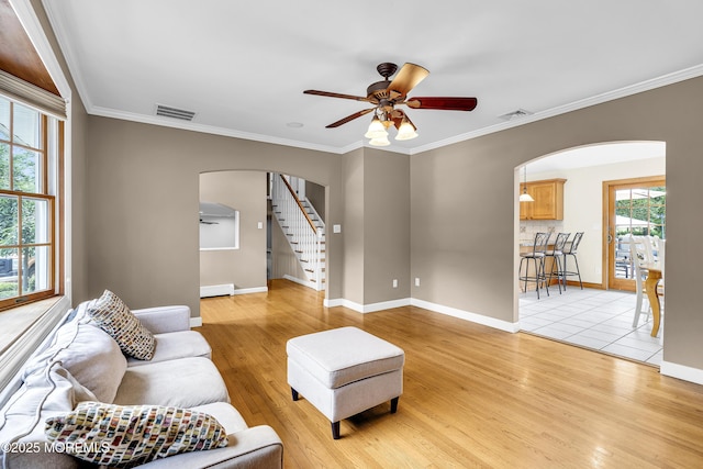 40 Centerville Rd, Holmdel, NJ 07733 - living room with arched walkways, ceiling fan, stairway, baseboard heating, and light wood finished floors