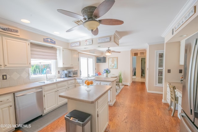 1920 Kenilworth Ct, Toms River, NJ 08753 - kitchen with stainless steel appliances, ceiling fan, a kitchen island, light countertops, and ornamental molding