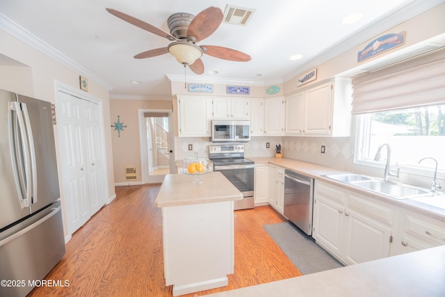 1920 Kenilworth Ct, Toms River, NJ 08753 - kitchen with stainless steel appliances, a center island, crown molding, light countertops, and white cabinetry