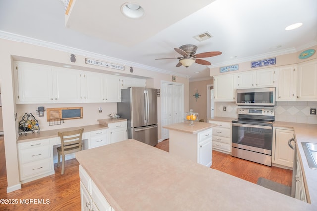 1920 Kenilworth Ct, Toms River, NJ 08753 - kitchen with stainless steel appliances, crown molding, a ceiling fan, built in desk, and light countertops