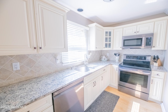 1920 Kenilworth Ct, Toms River, NJ 08753 - kitchen featuring stainless steel appliances, backsplash, light stone counters, glass insert cabinets, and light wood finished floors