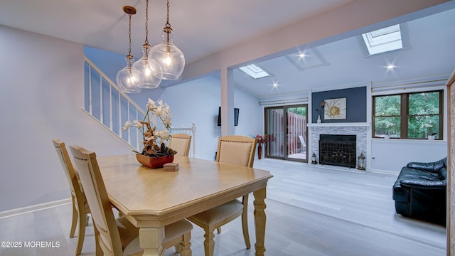 57 Chestnut Way, Manalapan, NJ 07726 - dining area featuring a skylight, stairway, wood finished floors, a fireplace with flush hearth, and vaulted ceiling
