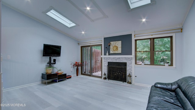 57 Chestnut Way, Manalapan, NJ 07726 - living room with a skylight, vaulted ceiling, a fireplace with raised hearth, wood finished floors, and recessed lighting