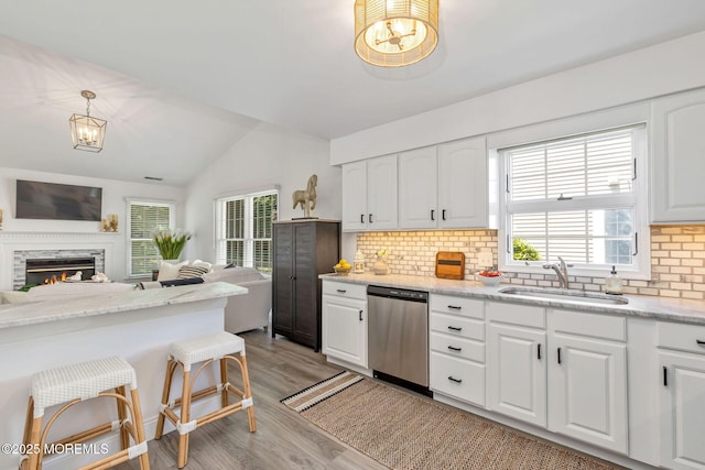 2254 S Chanticleer Ct, Toms River, NJ 08755 - kitchen with dishwasher, light wood-type flooring, backsplash, vaulted ceiling, and white cabinets