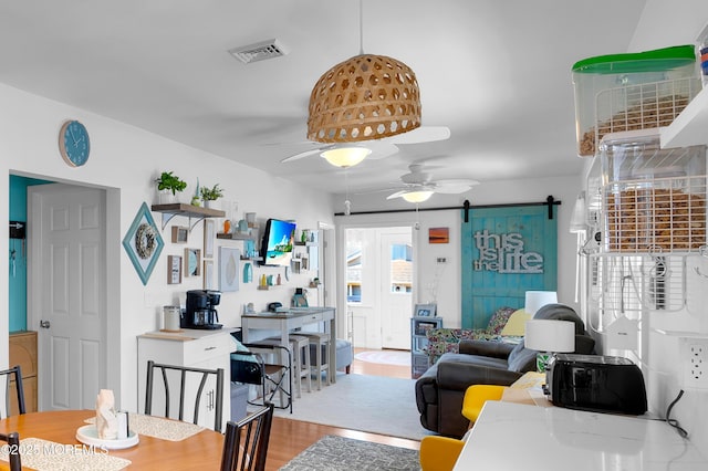 307 Webster Ave, Seaside Heights, NJ 08751 - dining space featuring a barn door, a ceiling fan, and light wood-type flooring