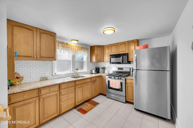307 Webster Ave, Seaside Heights, NJ 08751 - kitchen with appliances with stainless steel finishes, backsplash, light tile patterned floors, light stone countertops, and brown cabinets