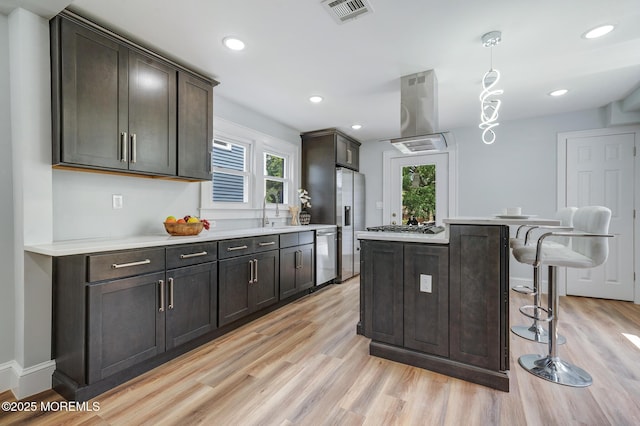 101 Broad St, Matawan, NJ 07747 - kitchen featuring island range hood, appliances with stainless steel finishes, light wood finished floors, a kitchen bar, and recessed lighting