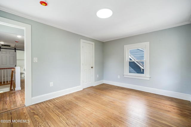 101 Broad St, Matawan, NJ 07747 - empty room with light wood-type flooring, ornamental molding, and a barn door