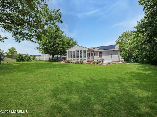 962 Columbus Dr, Brick, NJ 08724 - back of house with a sunroom, solar panels, and a fenced backyard