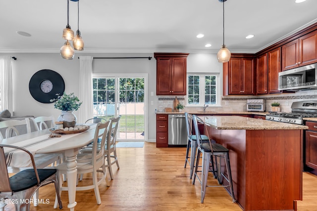 1667 Kalvel Ct, Toms River, NJ 08755 - kitchen featuring appliances with stainless steel finishes, ornamental molding, a center island, backsplash, and light wood finished floors
