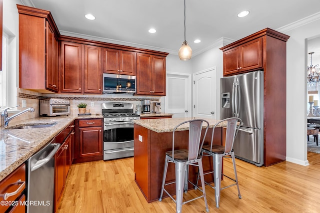1667 Kalvel Ct, Toms River, NJ 08755 - kitchen with stainless steel appliances, light wood-type flooring, crown molding, a kitchen island, and decorative backsplash