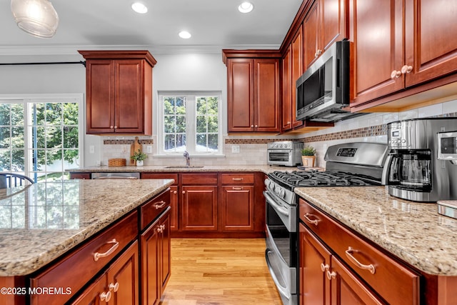 1667 Kalvel Ct, Toms River, NJ 08755 - kitchen featuring appliances with stainless steel finishes, light wood-type flooring, light stone countertops, ornamental molding, and backsplash