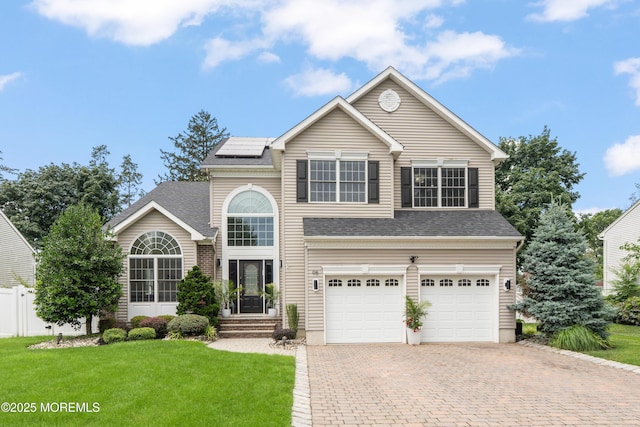 95 Linden Ave, West Long Branch, NJ 07764 - traditional-style house with a garage, driveway, solar panels, and roof with shingles