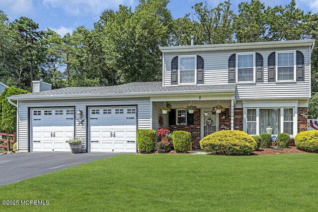 8 Yellowstone Ln, Howell, NJ 07731 - view of front of house featuring asphalt driveway, an attached garage, a front lawn, a chimney, and brick siding