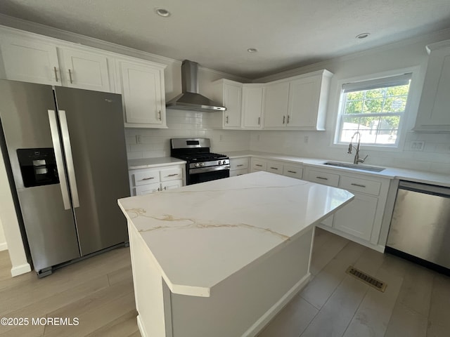 191 US Highway 9 Unit 14, Englishtown, NJ 07726 - kitchen with appliances with stainless steel finishes, wall chimney exhaust hood, ornamental molding, white cabinetry, and light wood-style flooring
