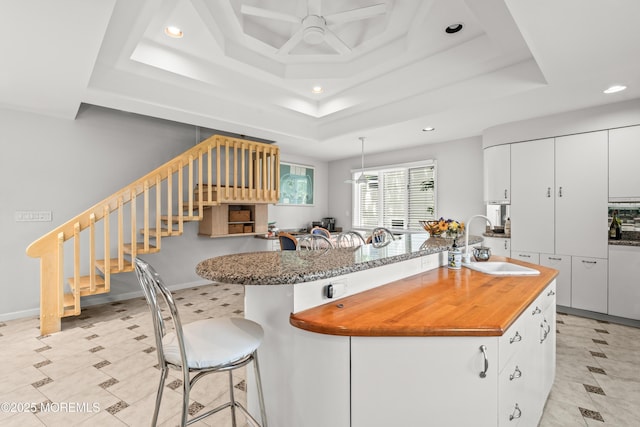 7 Wallace Ave, Oakhurst, NJ 07755 - kitchen featuring a tray ceiling, recessed lighting, a ceiling fan, a breakfast bar, and an island with sink