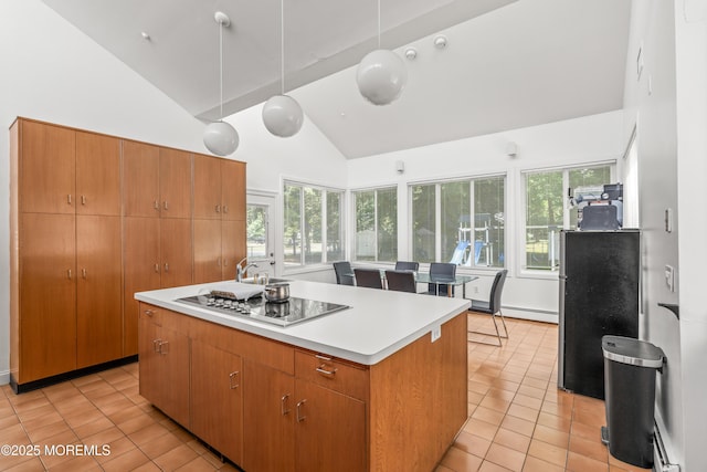 460 Runyan Ave, Deal, NJ 07723 - kitchen with light tile patterned floors, high vaulted ceiling, stainless steel cooktop, a kitchen island, and light countertops