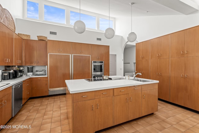 460 Runyan Ave, Deal, NJ 07723 - kitchen with high vaulted ceiling, appliances with stainless steel finishes, light tile patterned flooring, light countertops, and a center island with sink