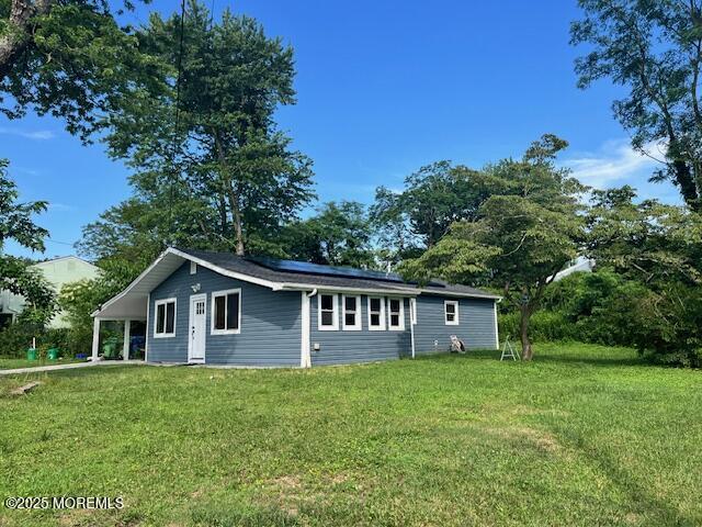 304 Palmer Ave, Neptune Township, NJ 07753 - view of side of home with solar panels, a lawn, and a carport