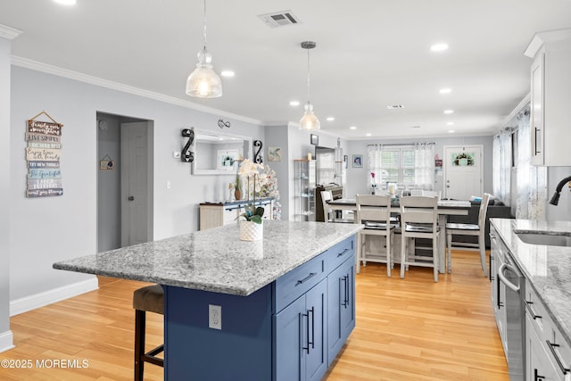410 Jamaica Blvd, Toms River, NJ 08757 - kitchen with crown molding, light wood-style floors, a kitchen breakfast bar, blue cabinets, and pendant lighting