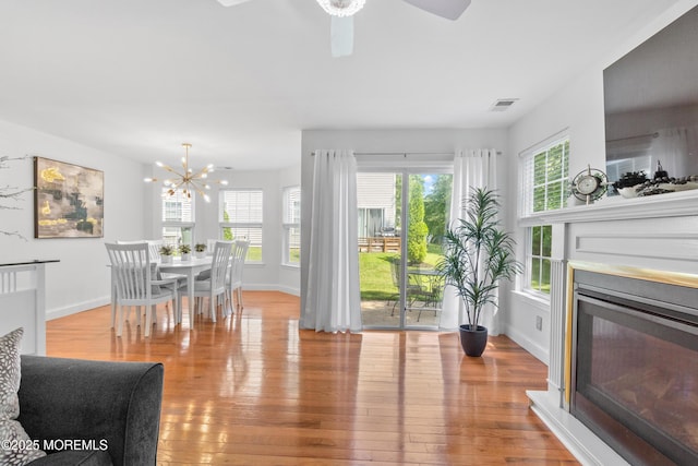 9 Nutmeg Ct, Tinton Falls, NJ 07753 - dining room featuring wood-type flooring, a glass covered fireplace, a chandelier, and a ceiling fan