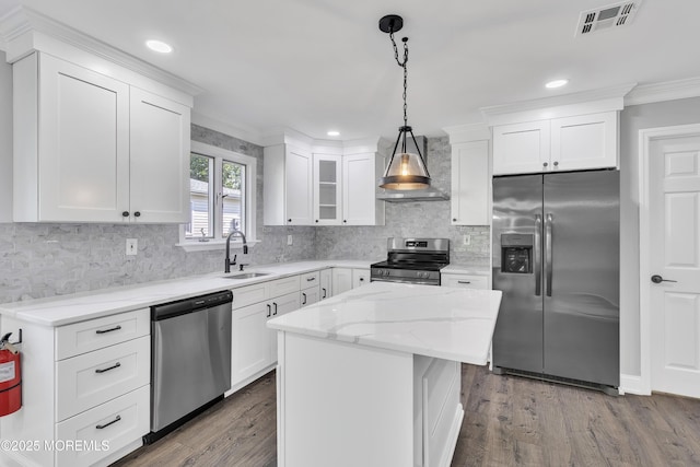 163 Courtshire Dr, Brick, NJ 08723 - kitchen with stainless steel appliances, wall chimney exhaust hood, white cabinetry, ornamental molding, and hanging light fixtures