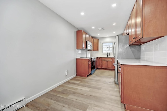 43 Cambridge Ct Unit K, Lakewood, NJ 08701 - kitchen featuring baseboard heating, stainless steel appliances, light wood finished floors, tasteful backsplash, and recessed lighting