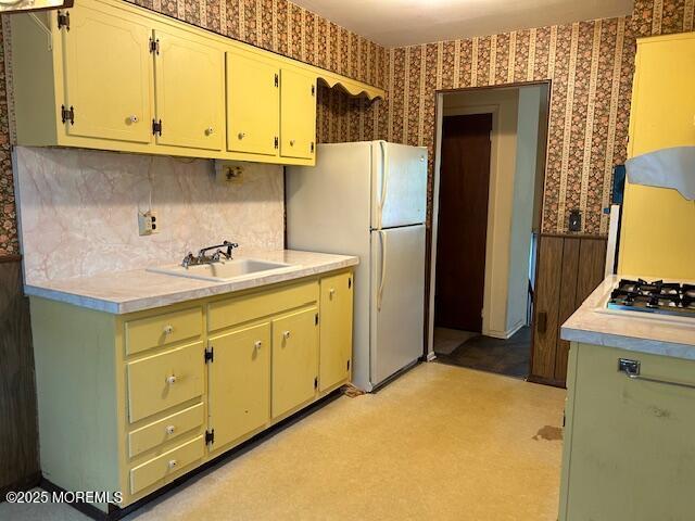 1599 Woodcrest Dr, Toms River, NJ 08753 - kitchen featuring wallpapered walls, freestanding refrigerator, stainless steel gas stovetop, light countertops, and tasteful backsplash