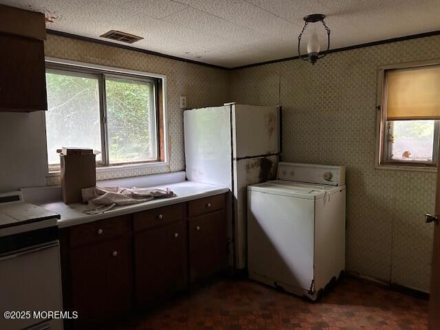 1599 Woodcrest Dr, Toms River, NJ 08753 - kitchen with washer / clothes dryer, light countertops, a textured ceiling, dark brown cabinetry, and wallpapered walls