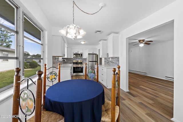 117 Clay Cir, Brick, NJ 08724 - dining area featuring baseboard heating, a chandelier, a ceiling fan, and wood finished floors