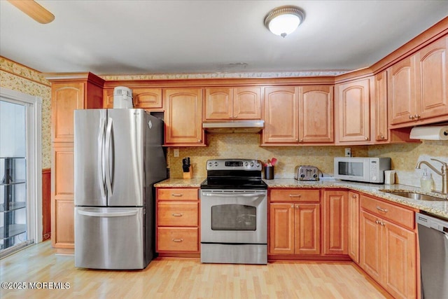 128 Korn Market Unit E, Freehold, NJ 07728 - kitchen featuring appliances with stainless steel finishes, light stone counters, light wood-type flooring, under cabinet range hood, and tasteful backsplash