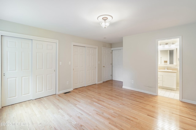 281 Hance Rd, Fair Haven, NJ 07704 - unfurnished bedroom featuring multiple closets, light wood-type flooring, and ensuite bathroom