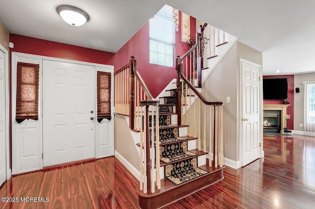 53 Grassmere Ct Unit 1, Freehold, NJ 07728 - foyer featuring wood finished floors, stairs, and a fireplace with flush hearth