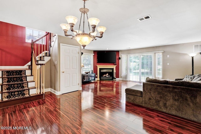 53 Grassmere Ct Unit 1, Freehold, NJ 07728 - living room featuring stairs, a chandelier, wood finished floors, and a lit fireplace