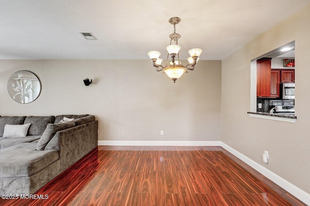 53 Grassmere Ct Unit 1, Freehold, NJ 07728 - living room with a chandelier and dark wood-style floors
