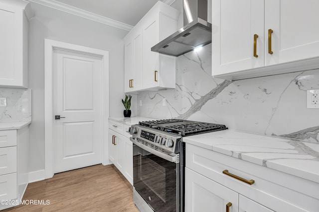127 Rogers St, Bayville, NJ 08721 - kitchen with gas range, wall chimney exhaust hood, tasteful backsplash, white cabinetry, and ornamental molding