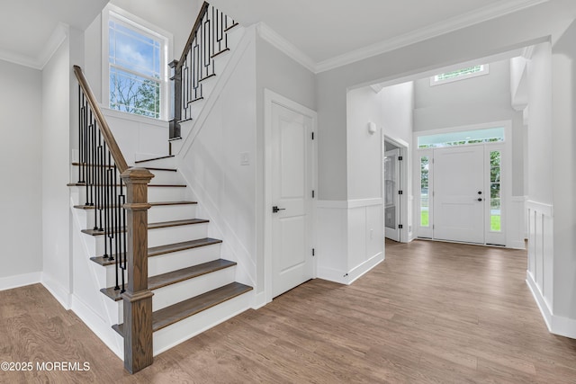 127 Rogers St, Bayville, NJ 08721 - entrance foyer featuring wood finished floors, stairs, wainscoting, ornamental molding, and a decorative wall