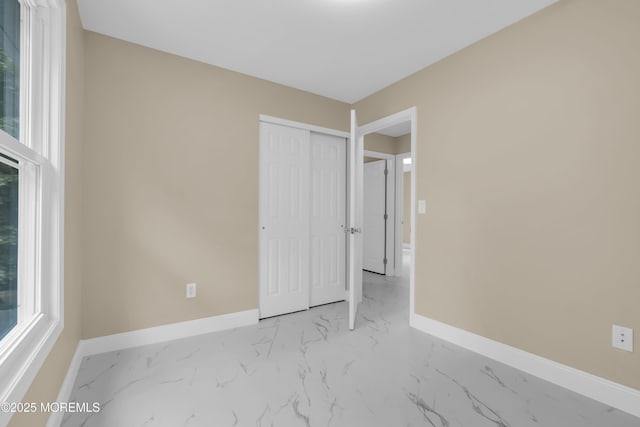 1066 Windlass Dr, Manahawkin, NJ 08050 - unfurnished bedroom featuring marble look tiles, a closet, and multiple windows