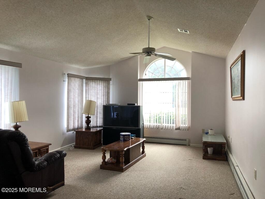 106 Narberth Way, Toms River, NJ 08757 - living room with baseboard heating, carpet flooring, a textured ceiling, ceiling fan, and vaulted ceiling