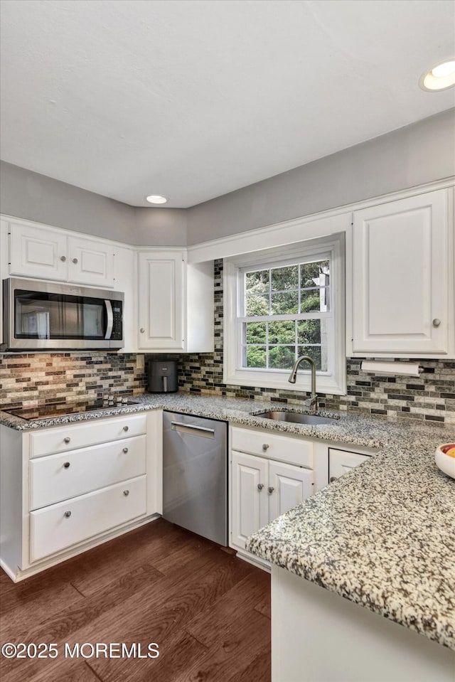 25 Forman Ln, Manalapan, NJ 07726 - kitchen with appliances with stainless steel finishes, decorative backsplash, dark wood finished floors, white cabinets, and light stone counters