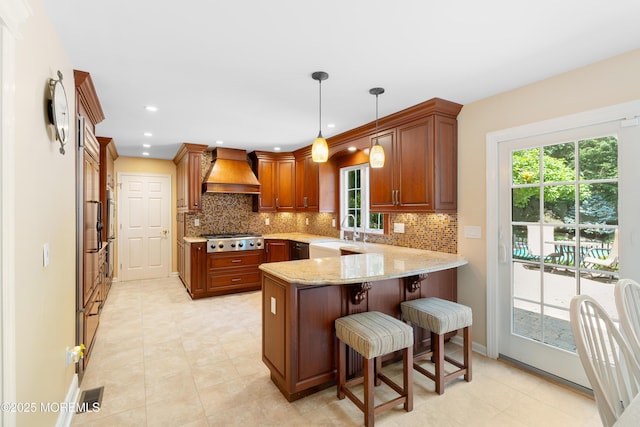7 Lorraine Ct, East Brunswick, NJ 08816 - kitchen with custom range hood, stainless steel gas cooktop, a peninsula, decorative backsplash, and a kitchen bar