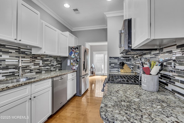 1602 Wagon Wheel Ct, Freehold, NJ 07728 - kitchen with appliances with stainless steel finishes, crown molding, white cabinetry, tasteful backsplash, and light stone countertops