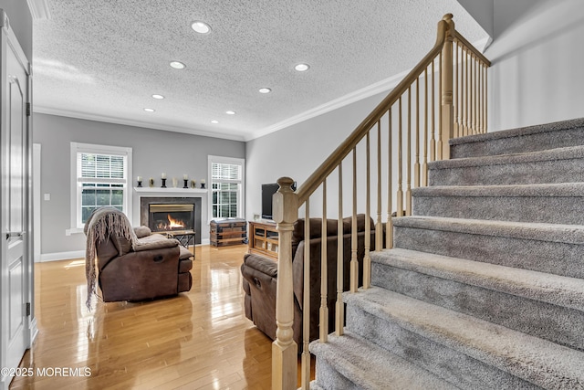 1602 Wagon Wheel Ct, Freehold, NJ 07728 - living area featuring ornamental molding, stairway, light wood-style floors, recessed lighting, and a glass covered fireplace