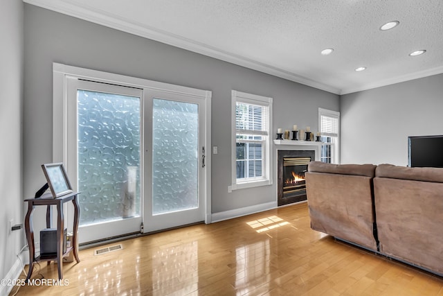 1602 Wagon Wheel Ct, Freehold, NJ 07728 - living area featuring crown molding, a textured ceiling, recessed lighting, wood finished floors, and a glass covered fireplace