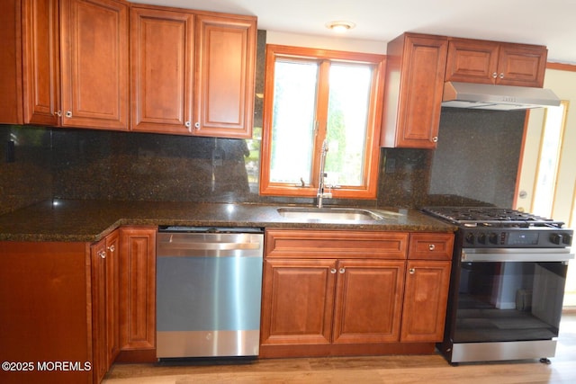 1111 River Ave, Point Pleasant, NJ 08742 - kitchen with stainless steel appliances, under cabinet range hood, brown cabinetry, and dark stone countertops