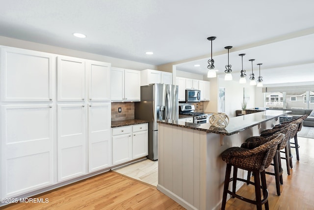 507 Amber St Unit B, Beach Haven, NJ 08008 - kitchen with appliances with stainless steel finishes, light wood-style flooring, a kitchen breakfast bar, white cabinetry, and recessed lighting