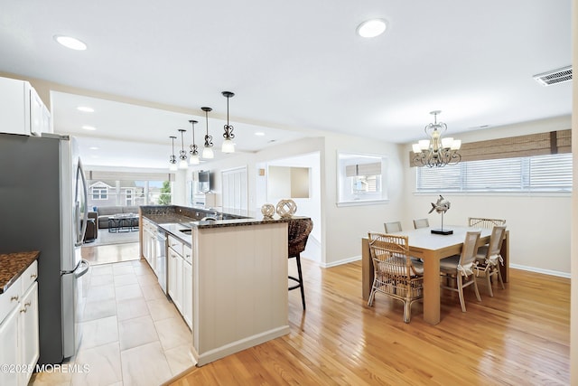 507 Amber St Unit B, Beach Haven, NJ 08008 - kitchen with appliances with stainless steel finishes, a kitchen bar, white cabinets, a chandelier, and recessed lighting