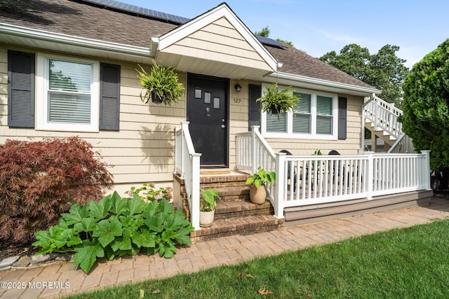 529 Smith Dr, Point Pleasant, NJ 08742 - view of front of home with roof with shingles, roof mounted solar panels, and stairs