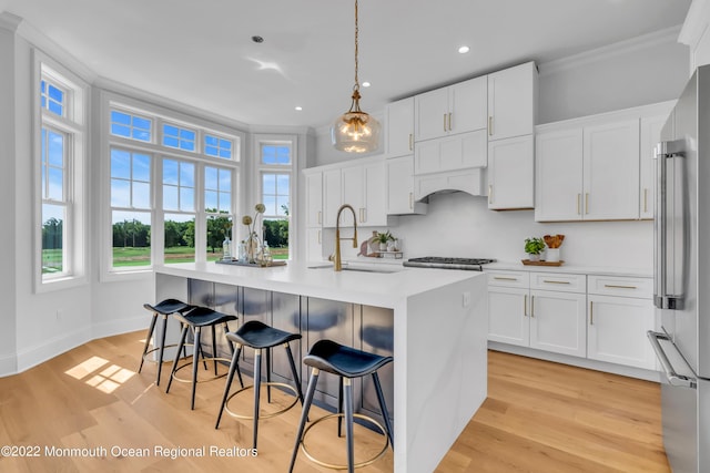116 Eagle Way, Eatontown, NJ 07724 - kitchen with crown molding, light countertops, a center island with sink, light wood-style floors, and white cabinetry